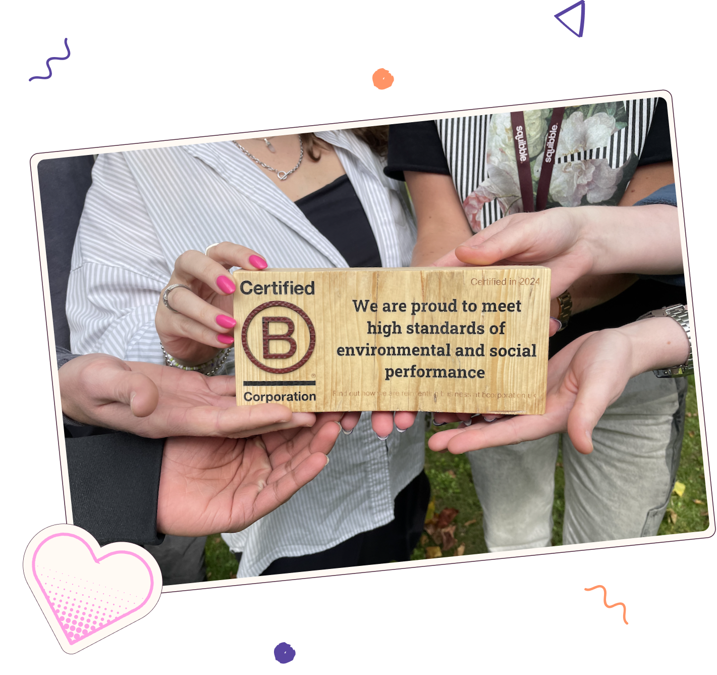 The Squibble team holding their B Corp certification plaque