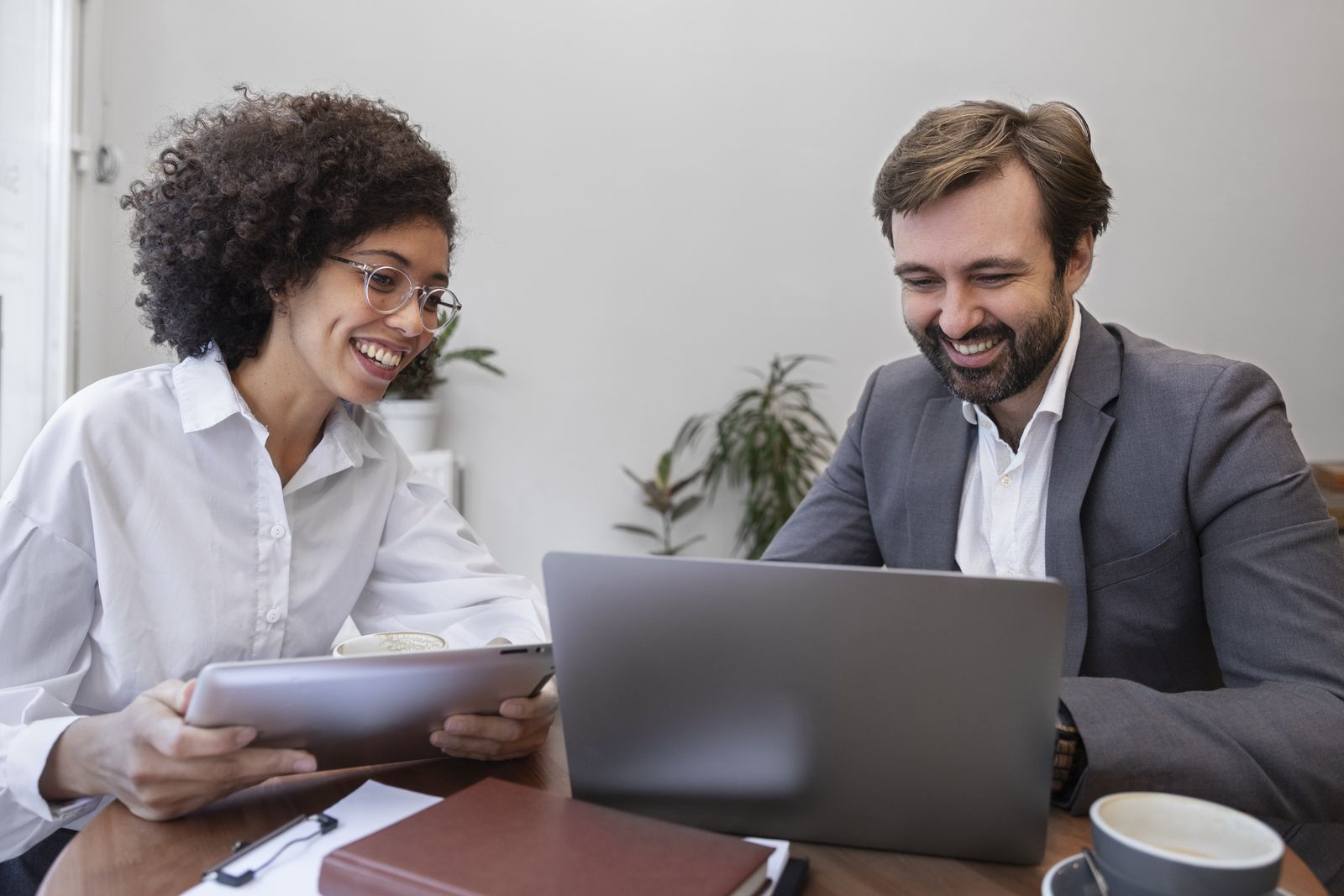 Consultant advising a client over a laptop
