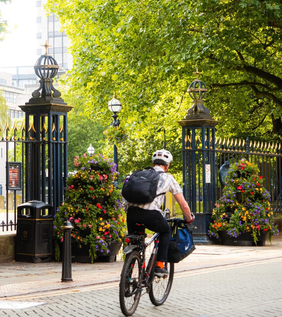 A cyclist passing the park gates