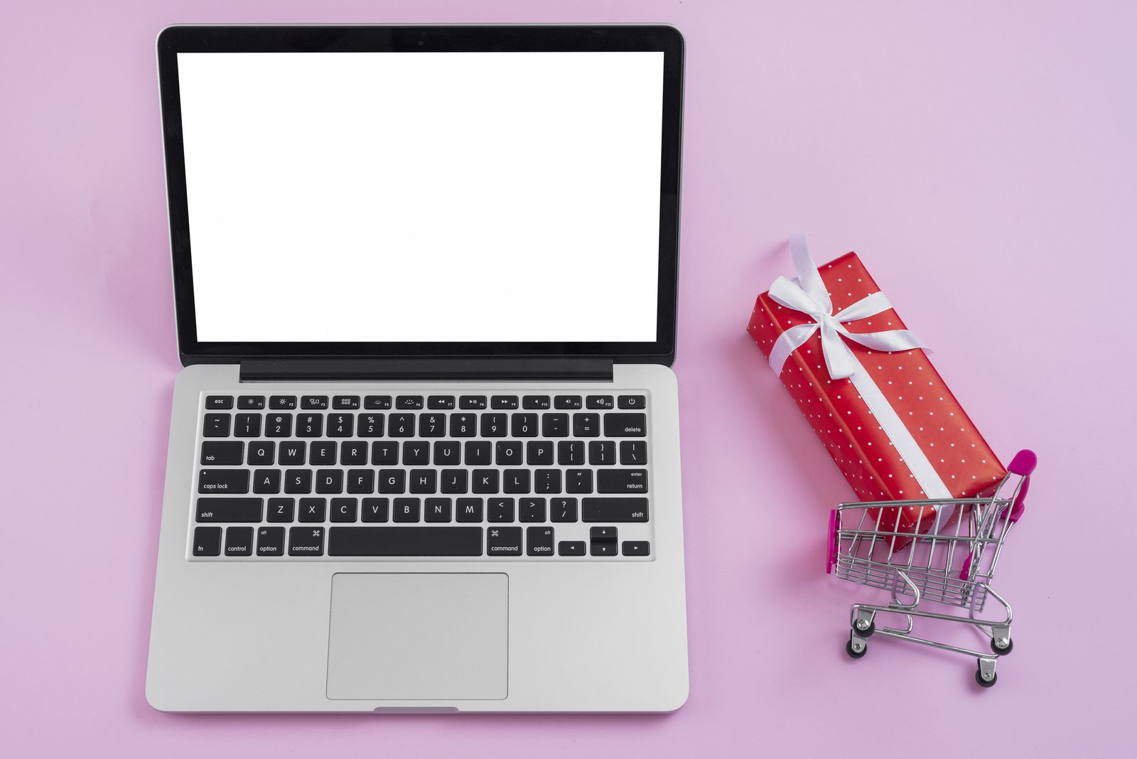 Laptop with a small shopping trolley and gift box