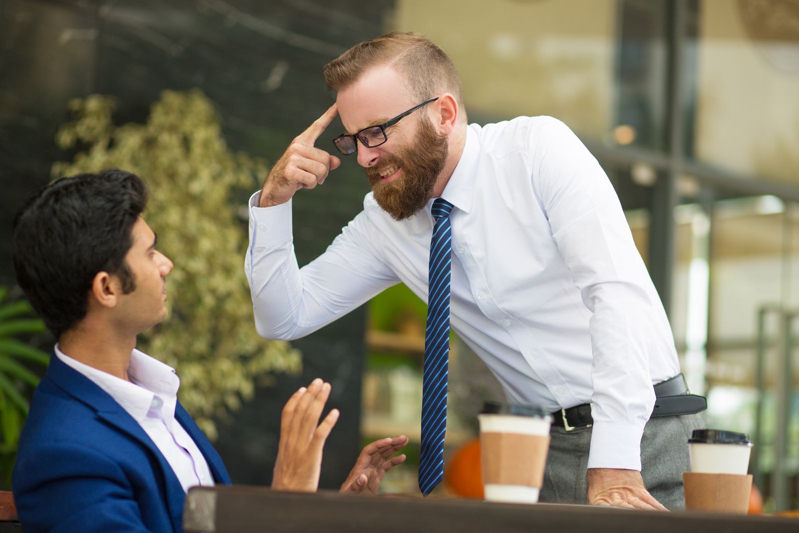 Manager making his point loudly to a colleague in a meeting