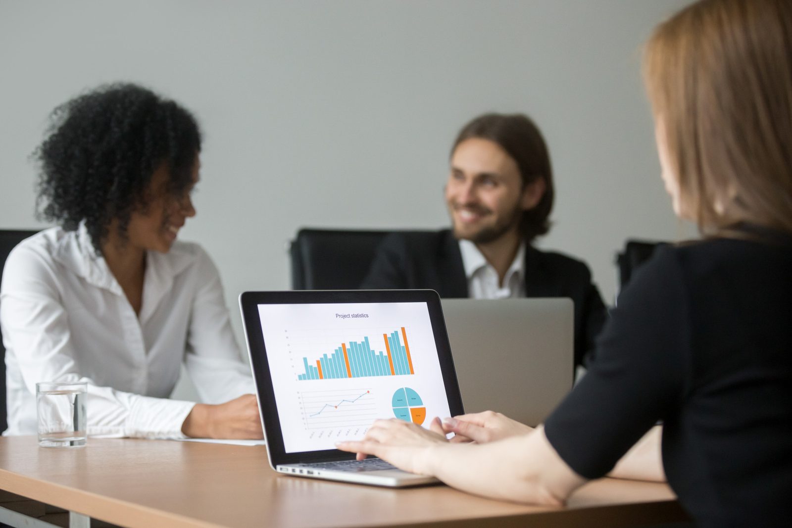 Team reviewing a results chart on a laptop in a meeting