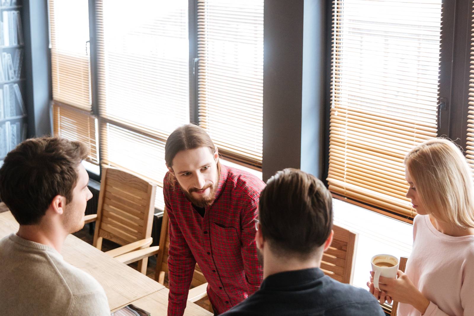 Four colleagues talking around a table in an office meeting