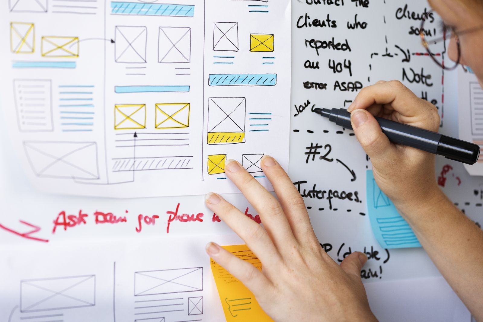 UX designer annotating wireframes with sticky notes